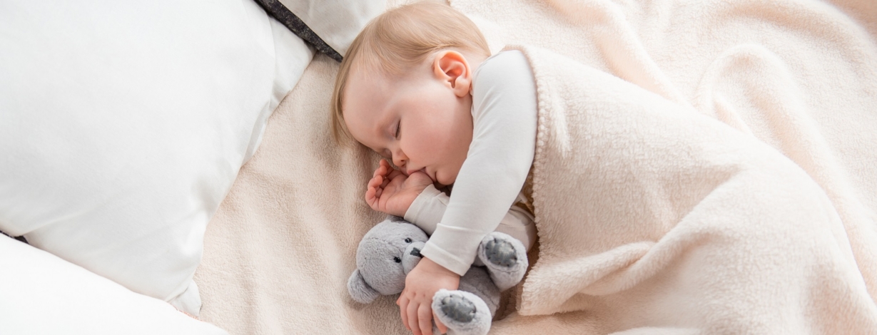 Infant putting hand in 2024 mouth